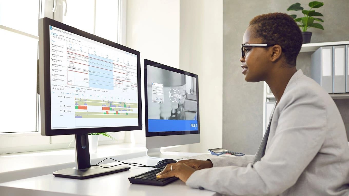 a Körber worker focused on a computer working on a PAS-X software