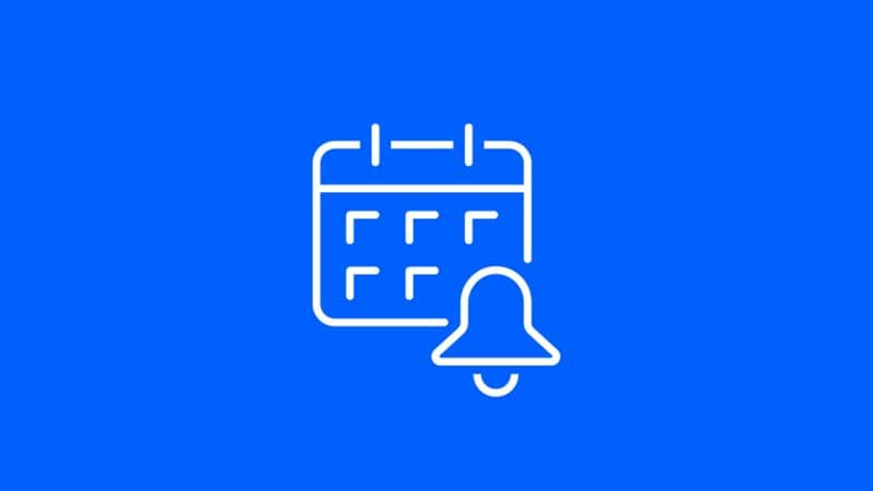 White icon of a calendar with a notification bell over a blue background. 