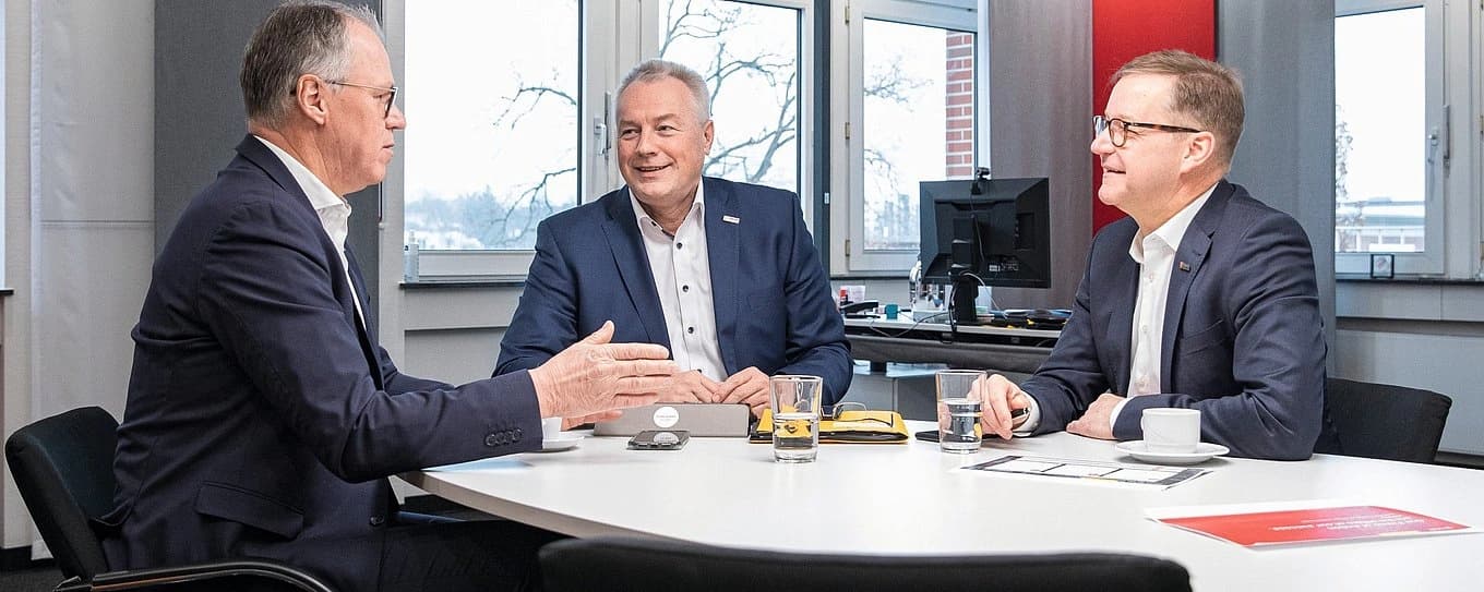 Dr. Jürgen Heller, Andreas Panz and Jürgen Spykman gathered around a table talking