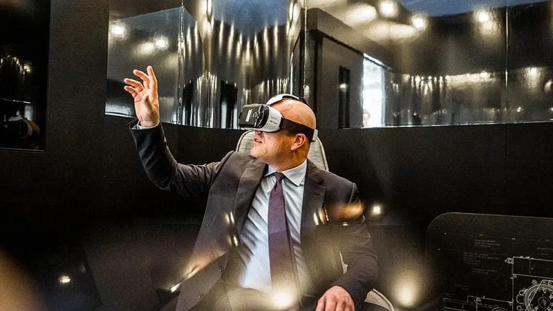 Ein Mann im Anzug benutzt ein Virtual-Reality-Headset und erkundet eine digitale Welt durch immersive Technologie.