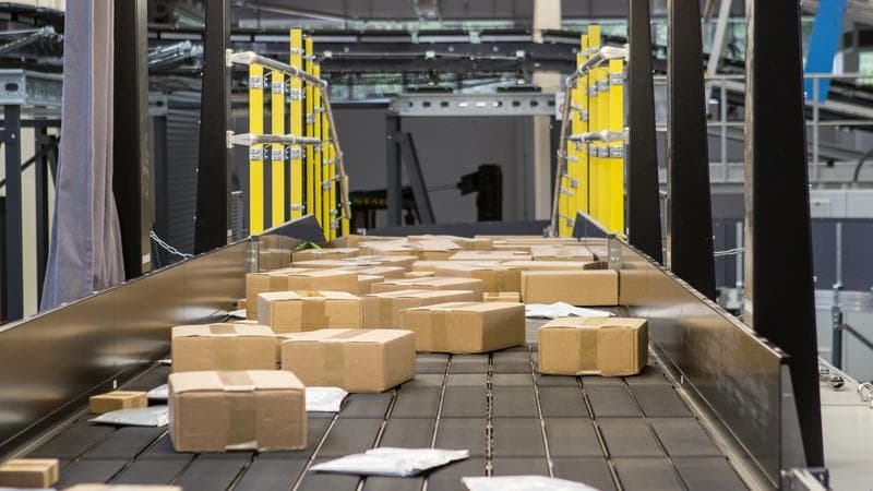 Kisten werden auf Bändern transportiert, die zu einer von Körber entwickelten Maschine gehören.
