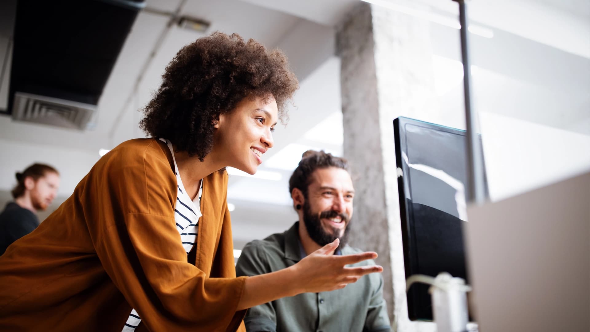 Two people collaborate on a computer, focusing on cybersecurity awareness and best practices