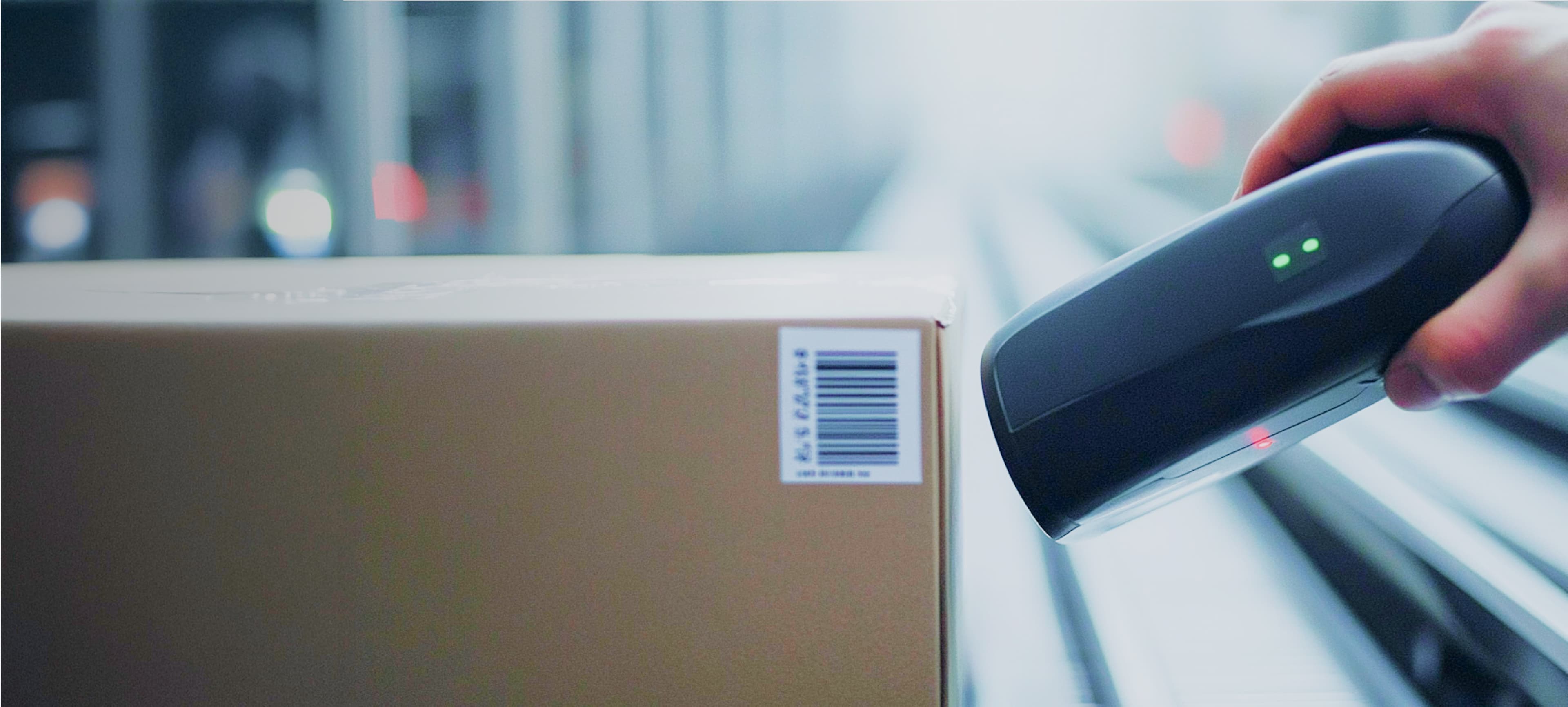 Nahaufnahme einer Hand, die einen Strichcode auf einem Paket scannt
