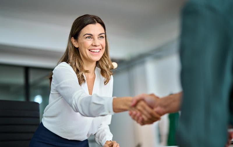 Executive woman shaking hands in a professional setting