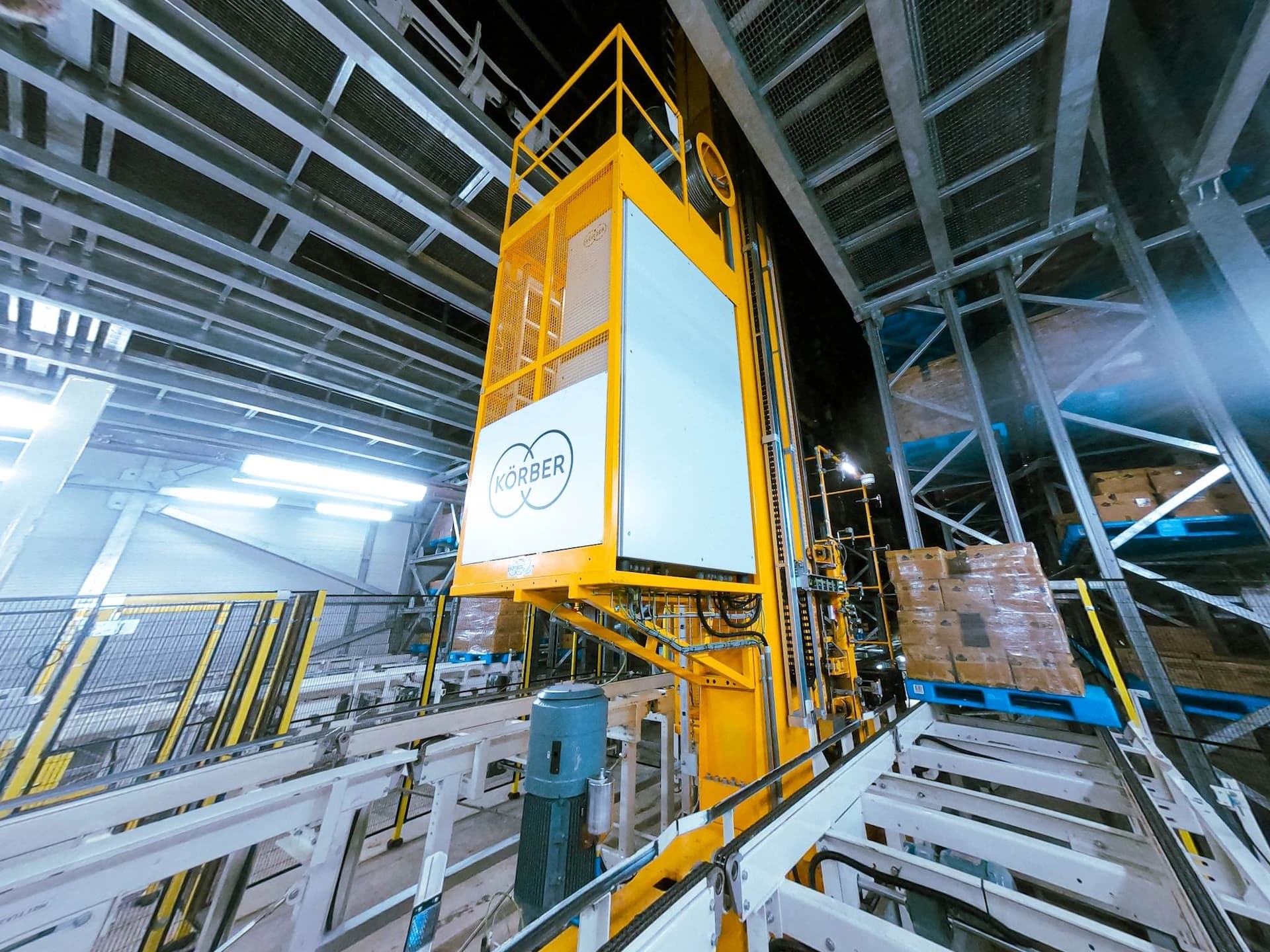 A large yellow lift positioned in BigBlue Logistics warehouse, ready for use in material handling tasks.