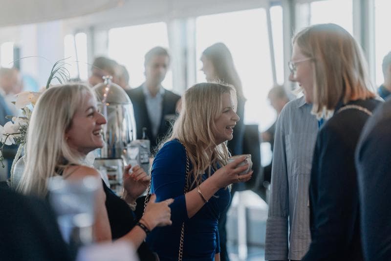 Körber-Mitarbeiterinnen und -Mitarbeiter beim fröhlichen Networking auf einer Firmenveranstaltung.