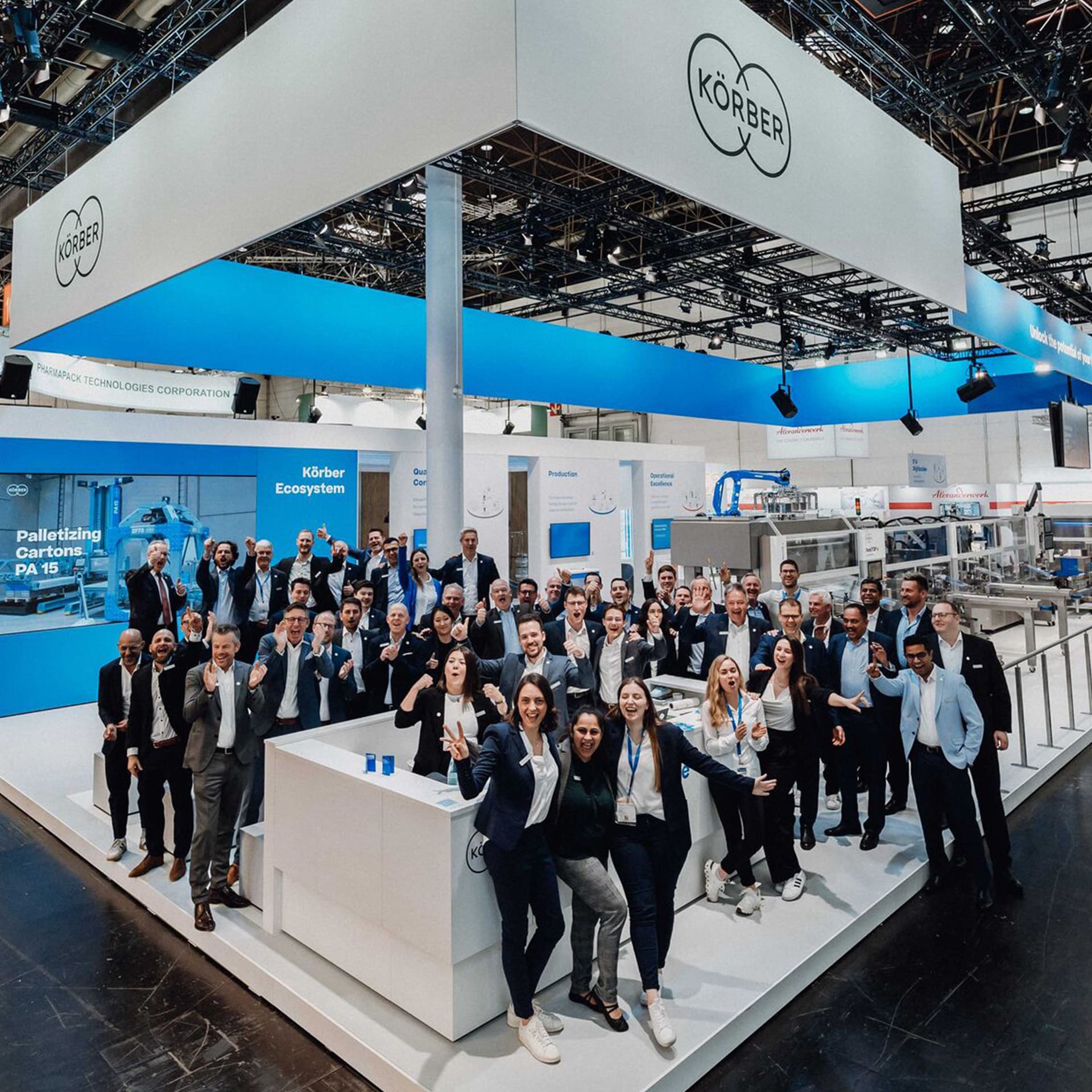 Gruppenbild von Körber-Mitarbeitern an einem gebrandeten Messestand