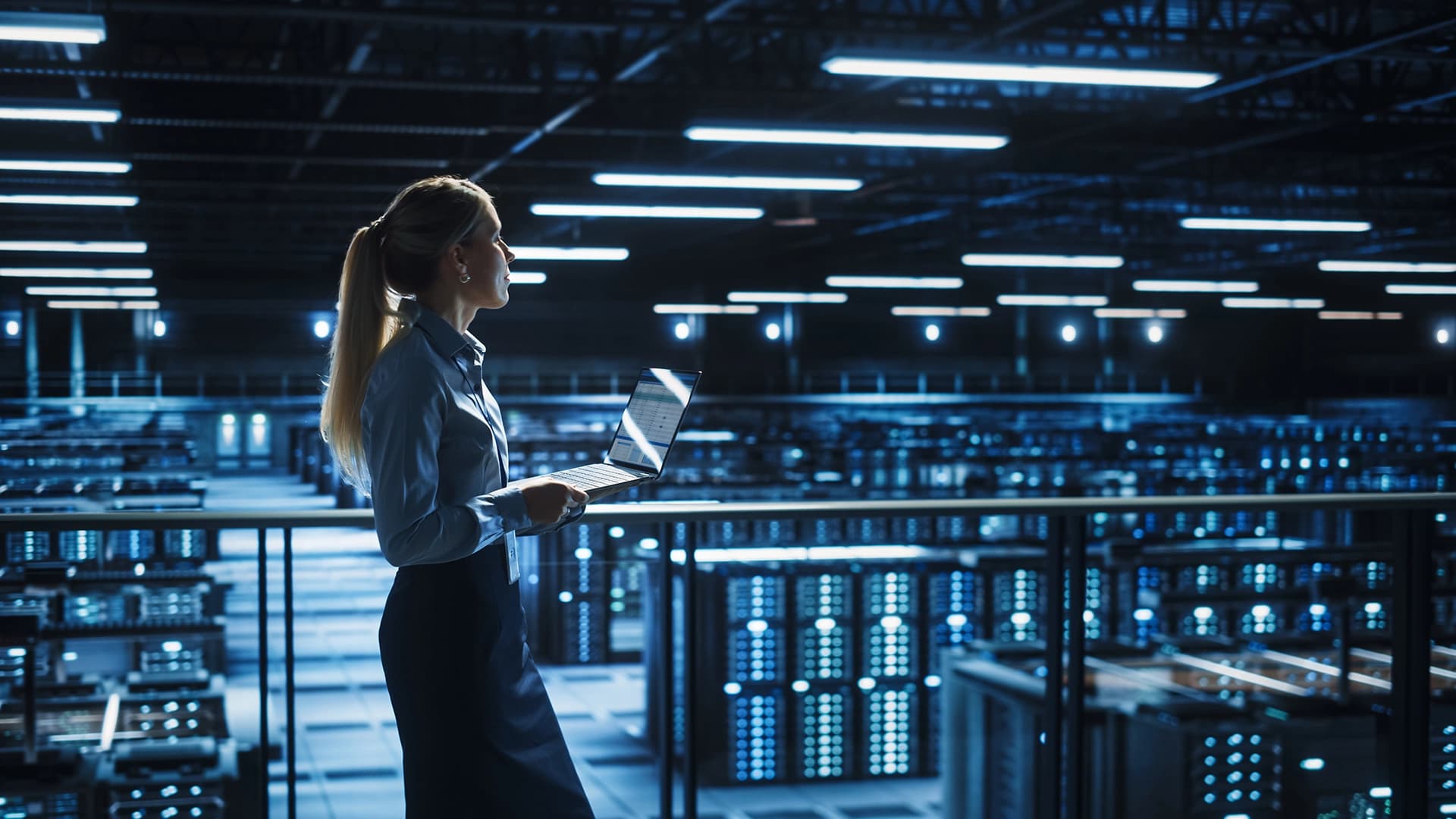Professional using a laptop in a data center, illustrating cloud-based PAS-X MES delivery and operation with AWS.
