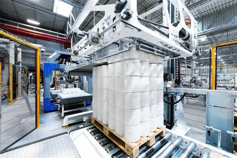 Der Lagenpalettierer PA15 von Korber stapelt aktiv Wasserflaschen für die Verpackung in einer Produktionsstätte.