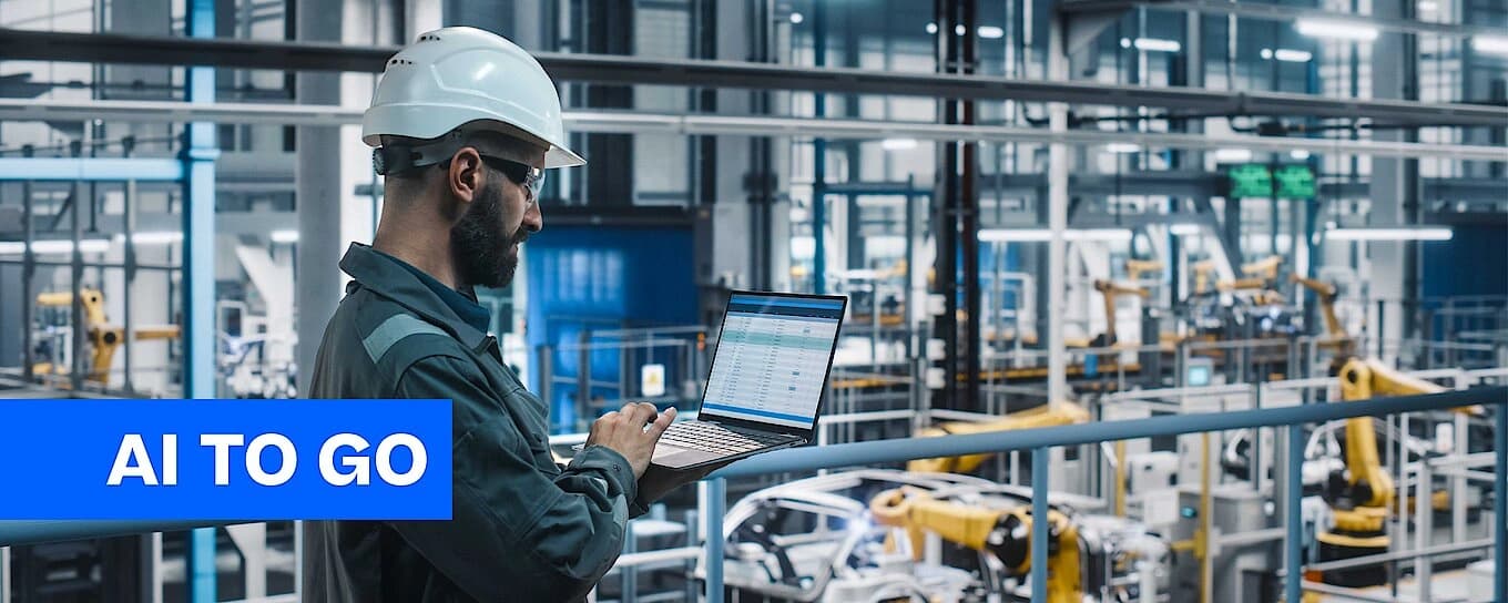 Arbeiter mit Schutzhelm, der in einer Lagerumgebung einen Computer bedient.