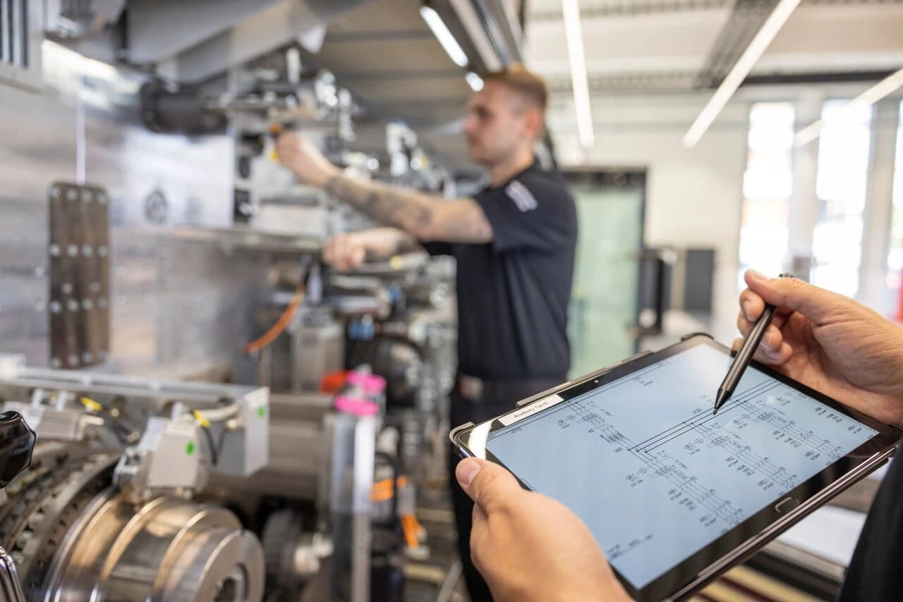 A person using a tablet to examine a machine on the Körber Academy platform.