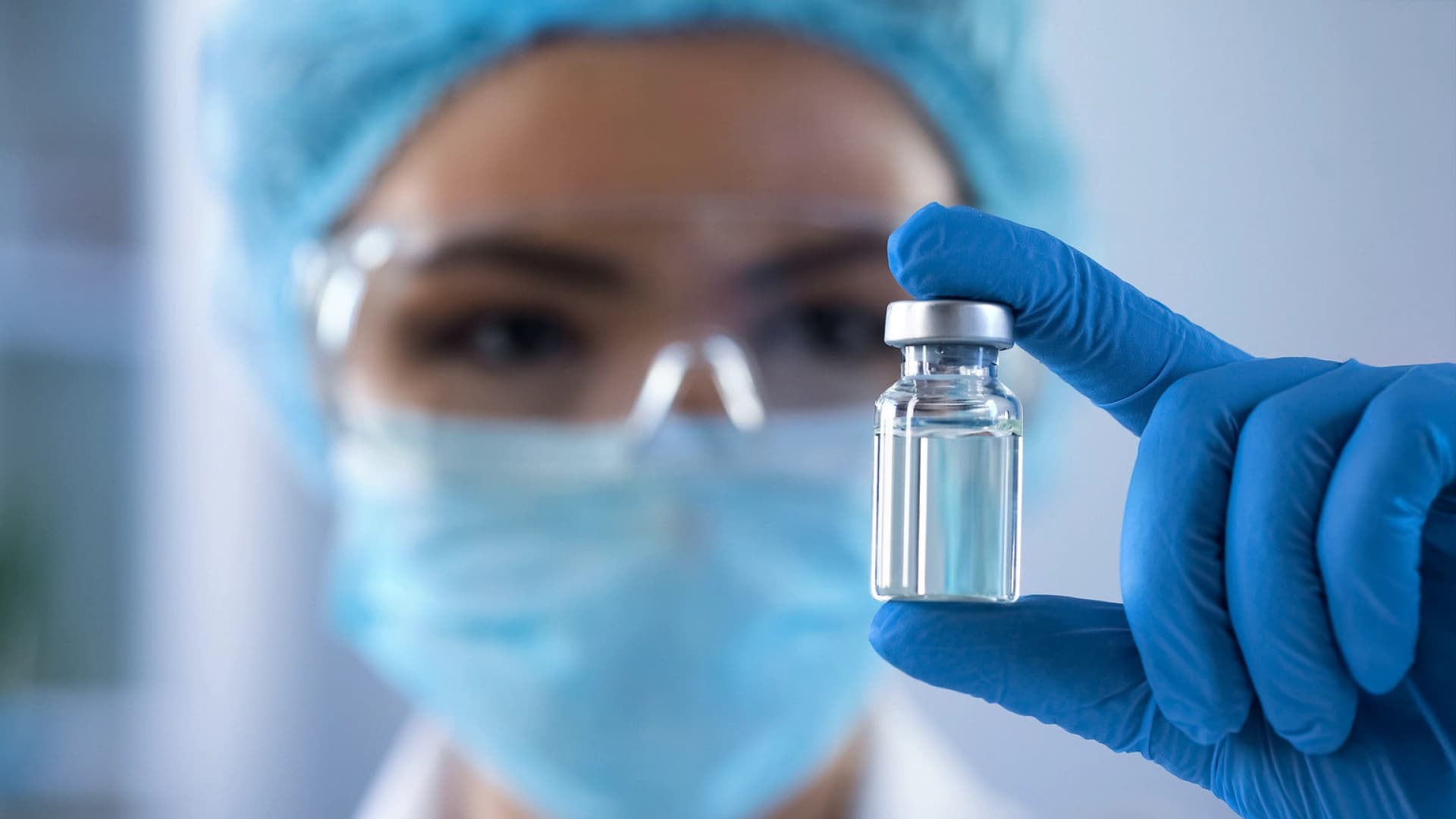 Körber-Mitarbeiter mit Chemieschutzbrille und einem kleinen Pharmafläschchen mit Medikamenten.