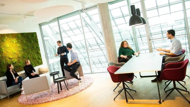 A group of people sitting around a table in an office