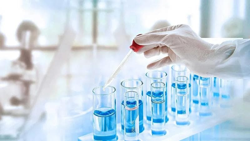Labortechniker transferiert Flüssigkeiten mit einer Pipette in Labor-Vials.