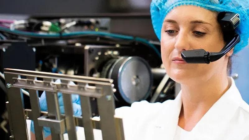 Arbeiten mit Schutzausrüstung und Headset, Blick auf eine Pharmamaschine.