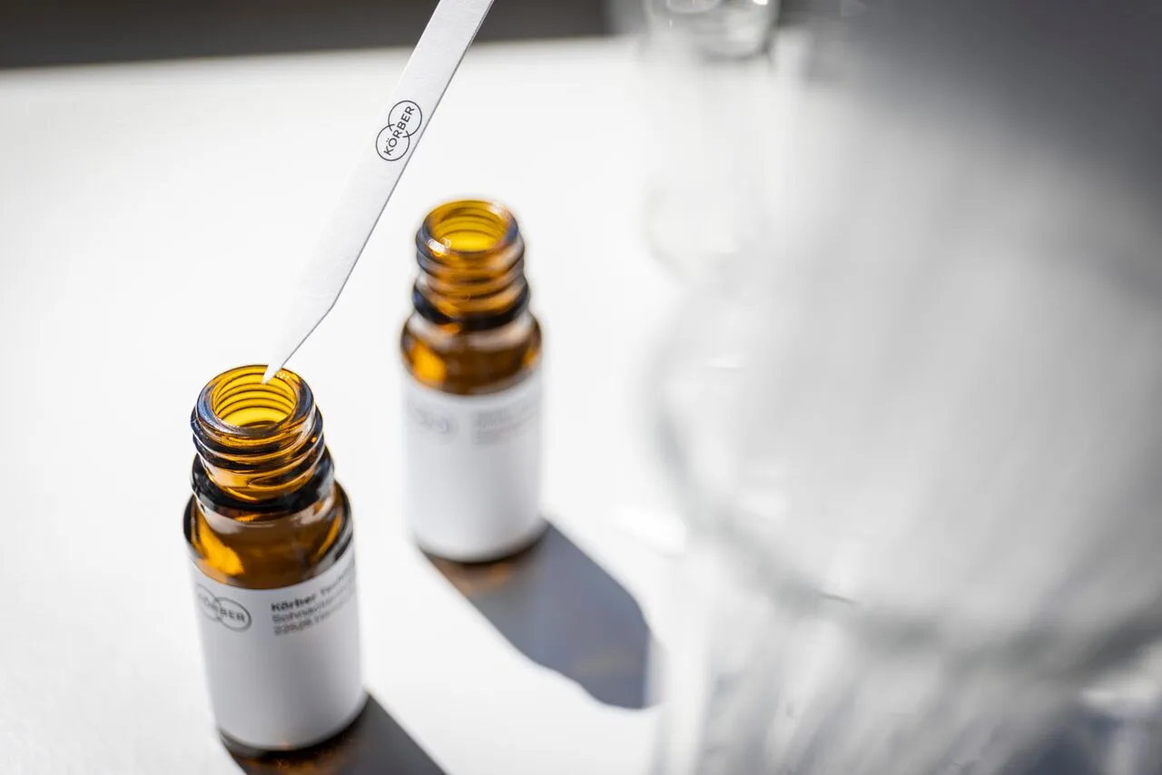 A clear bottle filled with a colorful liquid, placed on a neutral background.