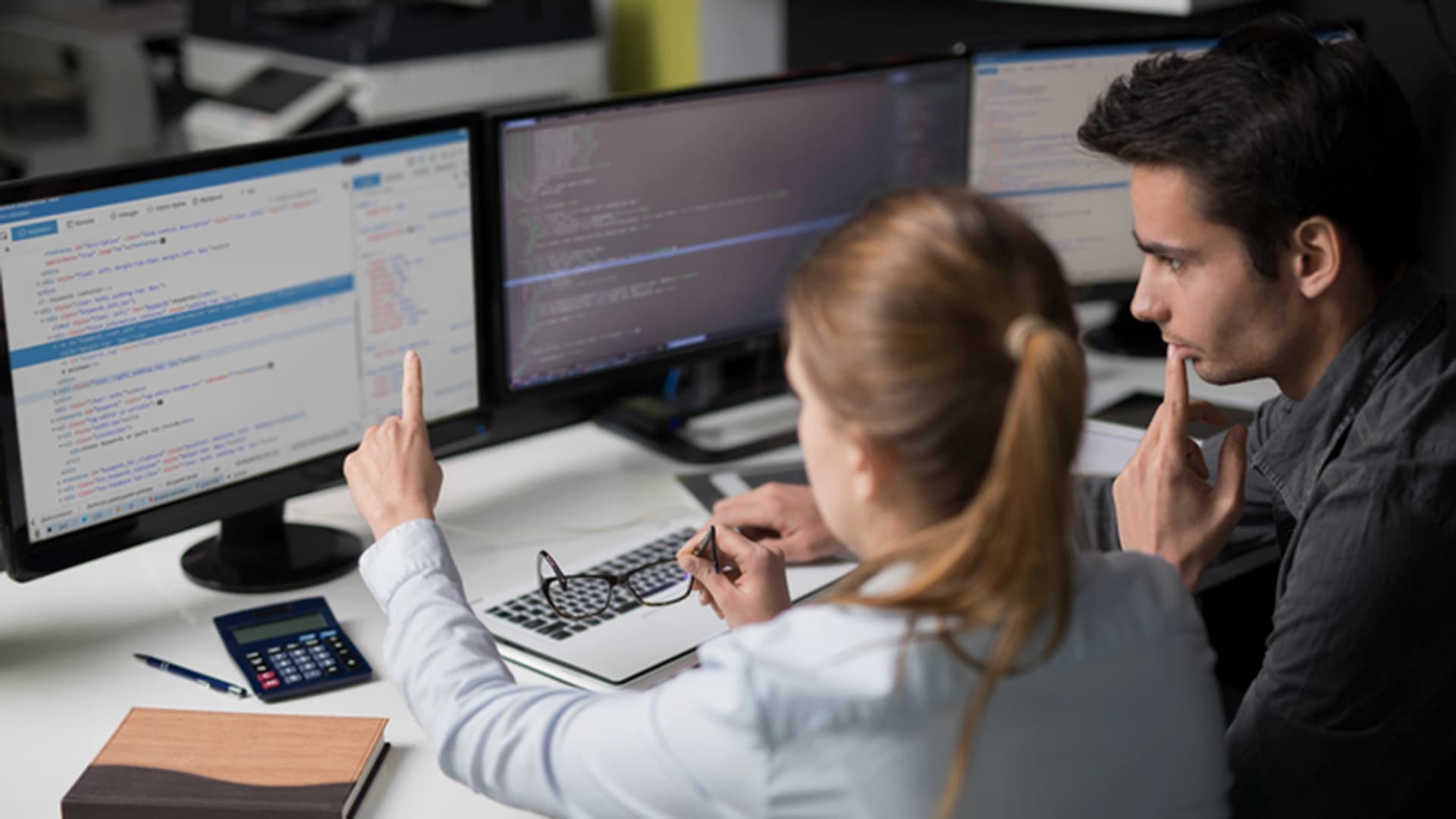 Ein Mann und eine Frau analysieren Grafiken an einem Computer