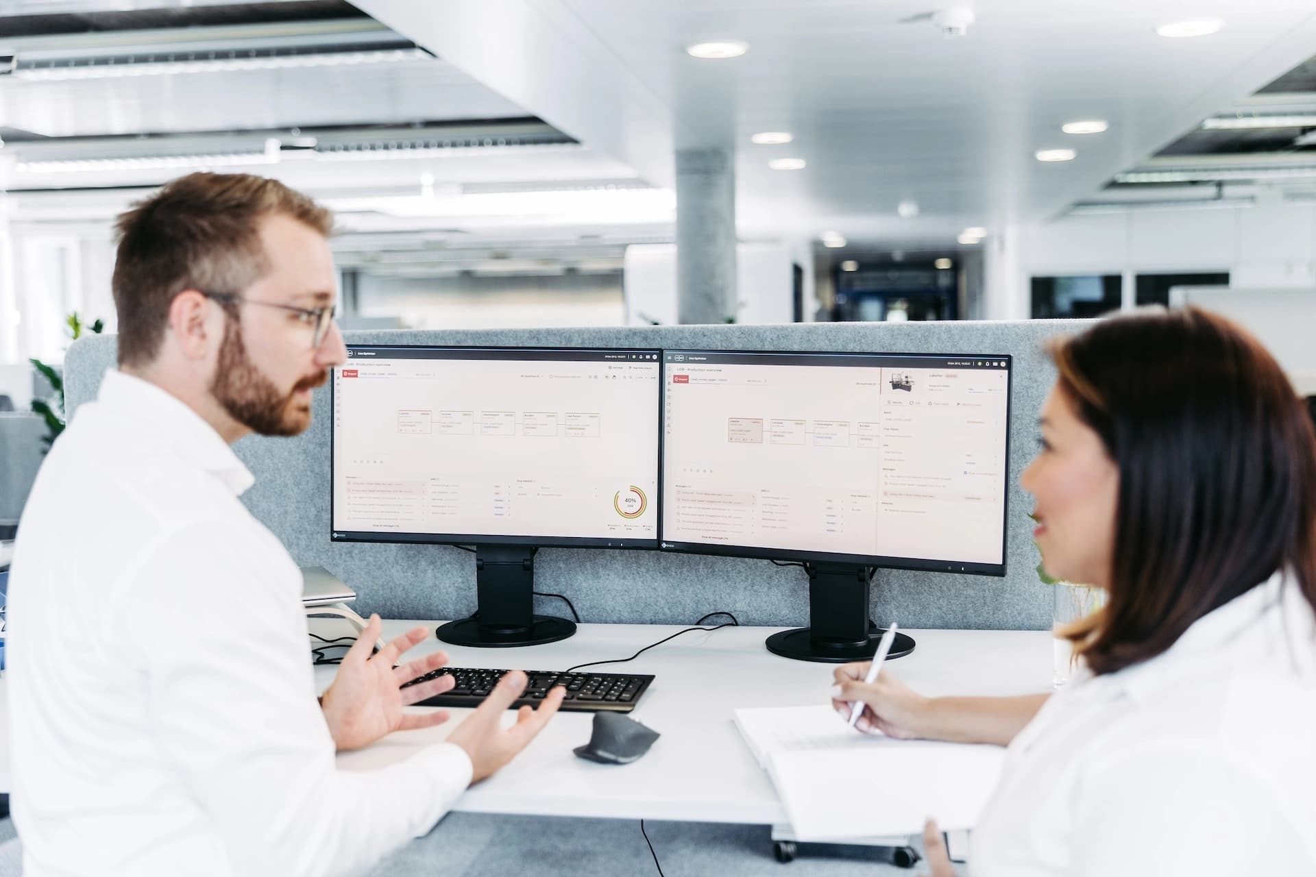 a man and a woman working on pharma line optimizer software