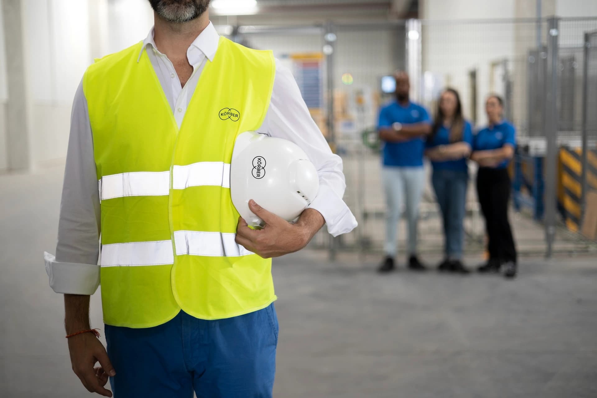 a Körber employee holding a safety helmet