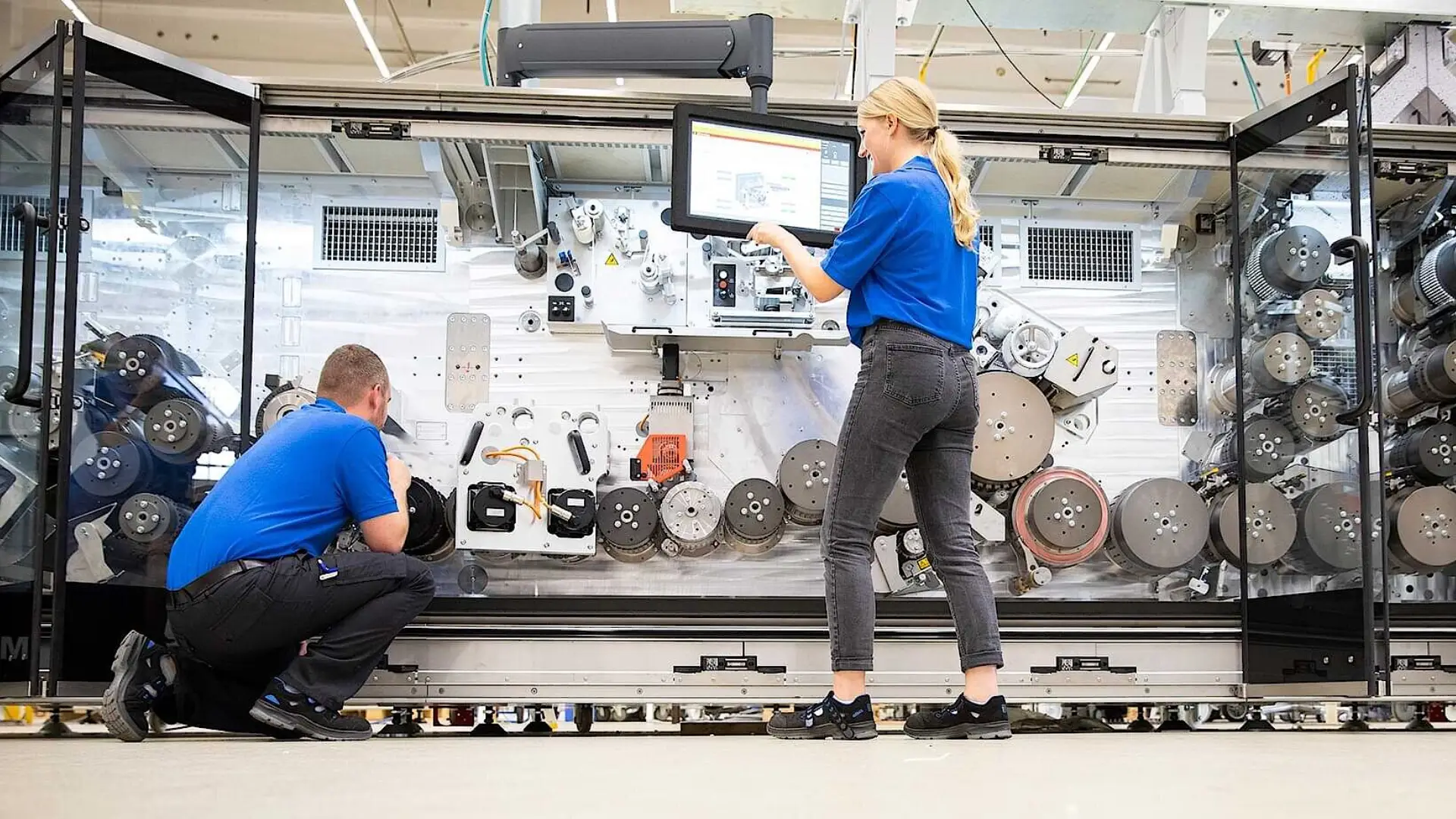 Two Körber employees fixing a machine.