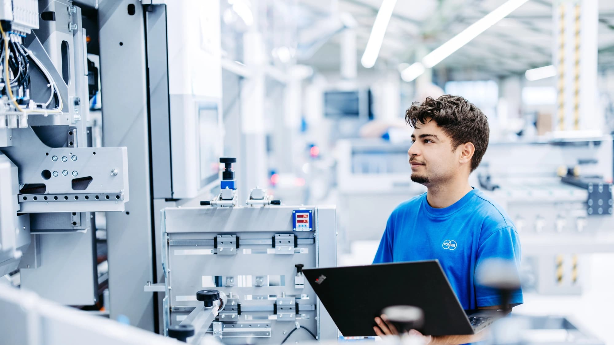 ein Körber-Mitarbeiter bei der Arbeit an einem Computer in einer Lagerumgebung
