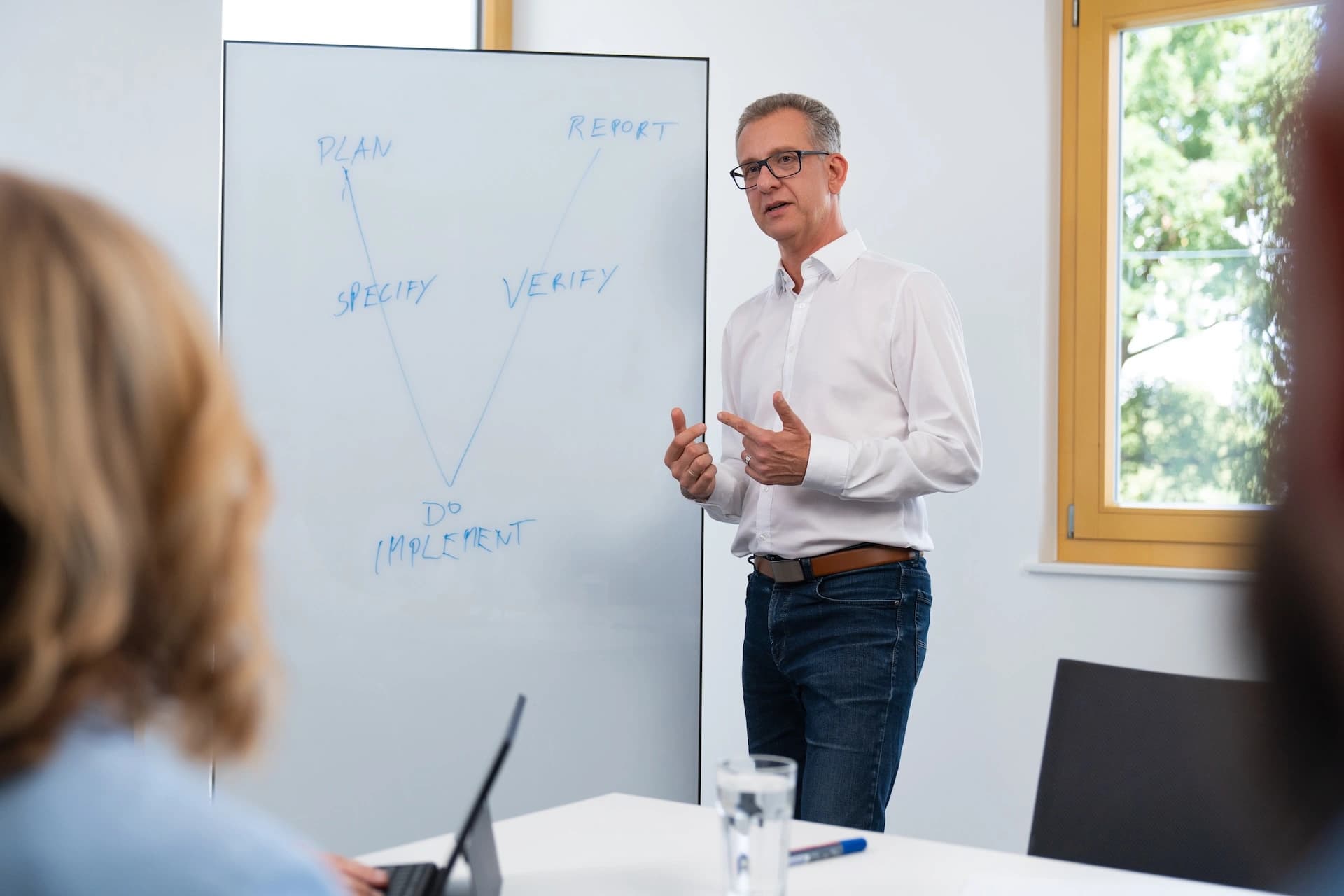 Ein Körber-Mitarbeiter präsentiert einer Gruppe von Personen ein Whiteboard