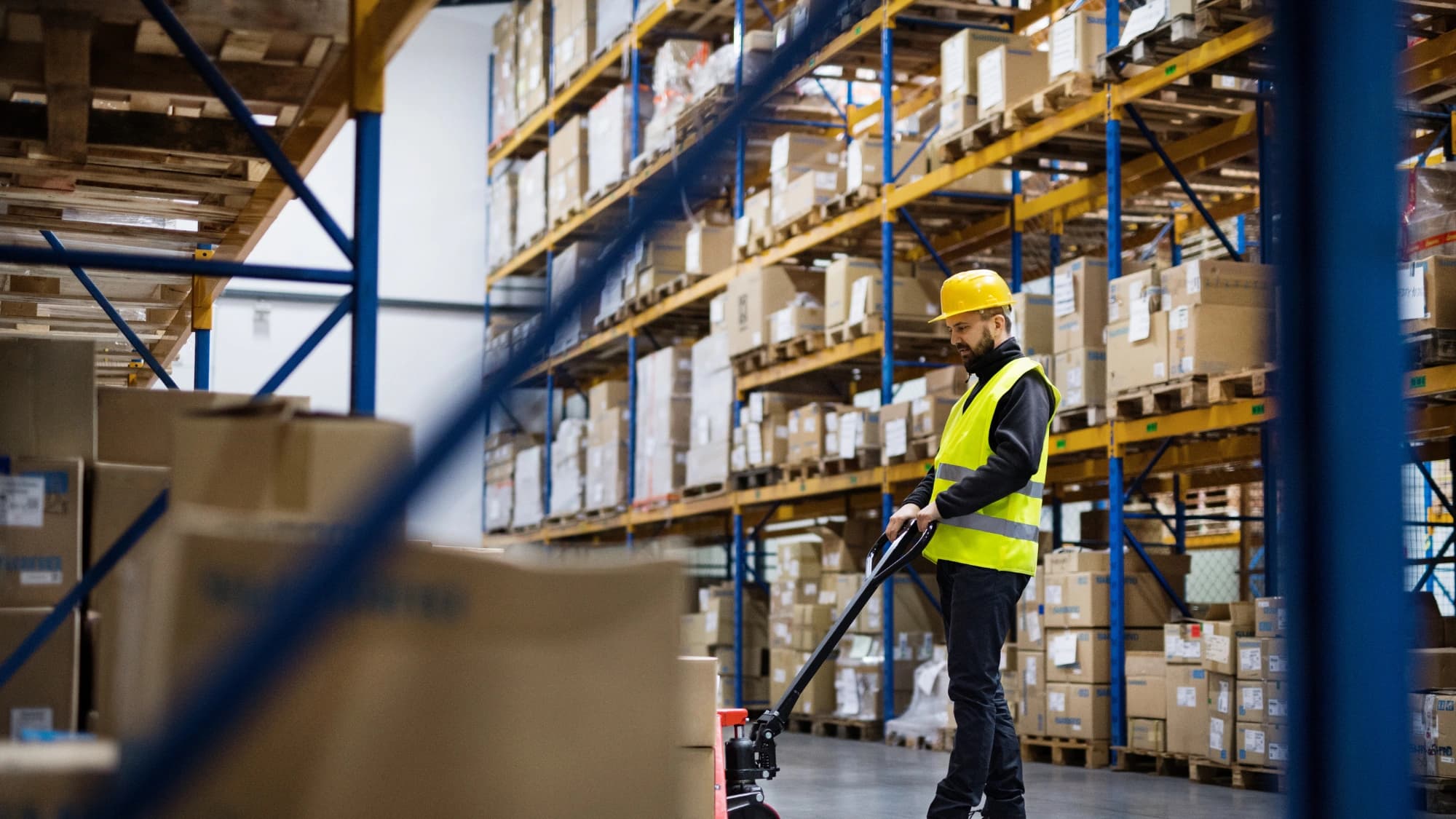 a man moving pallets across a warehouse