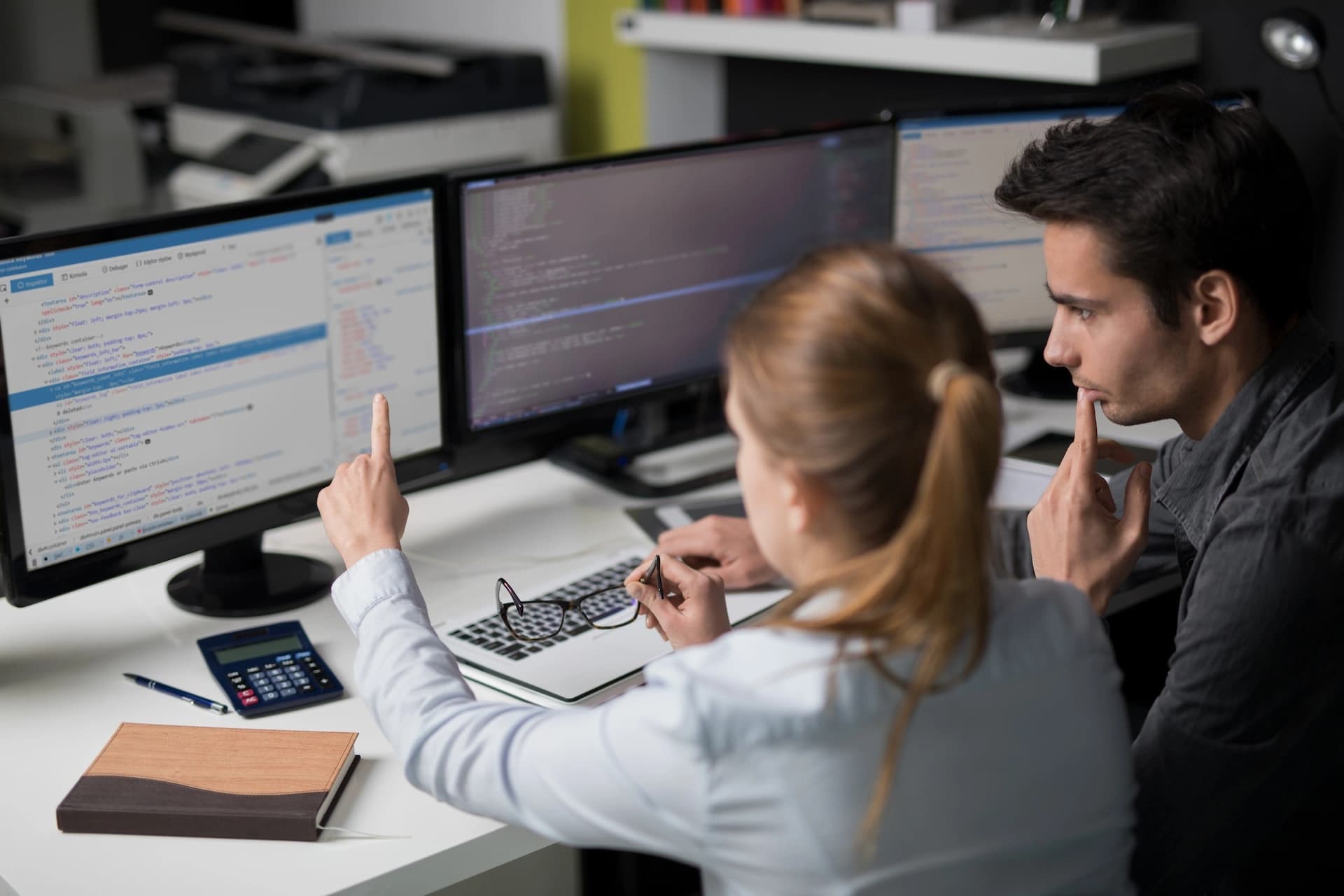 ein Mann und eine Frau, konzentriert an einem Computer