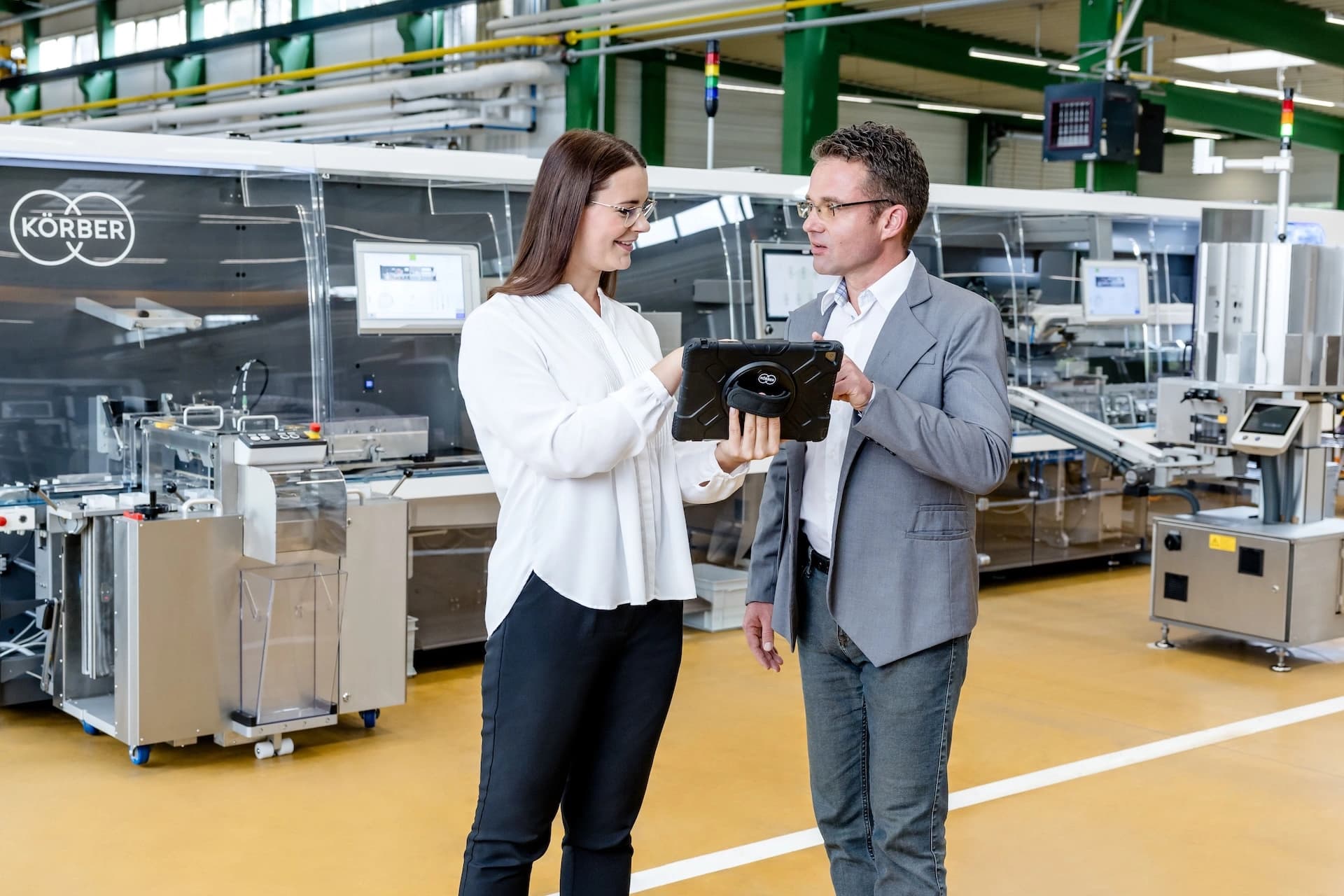 a man and a woman discussing in front of a pharma machine
