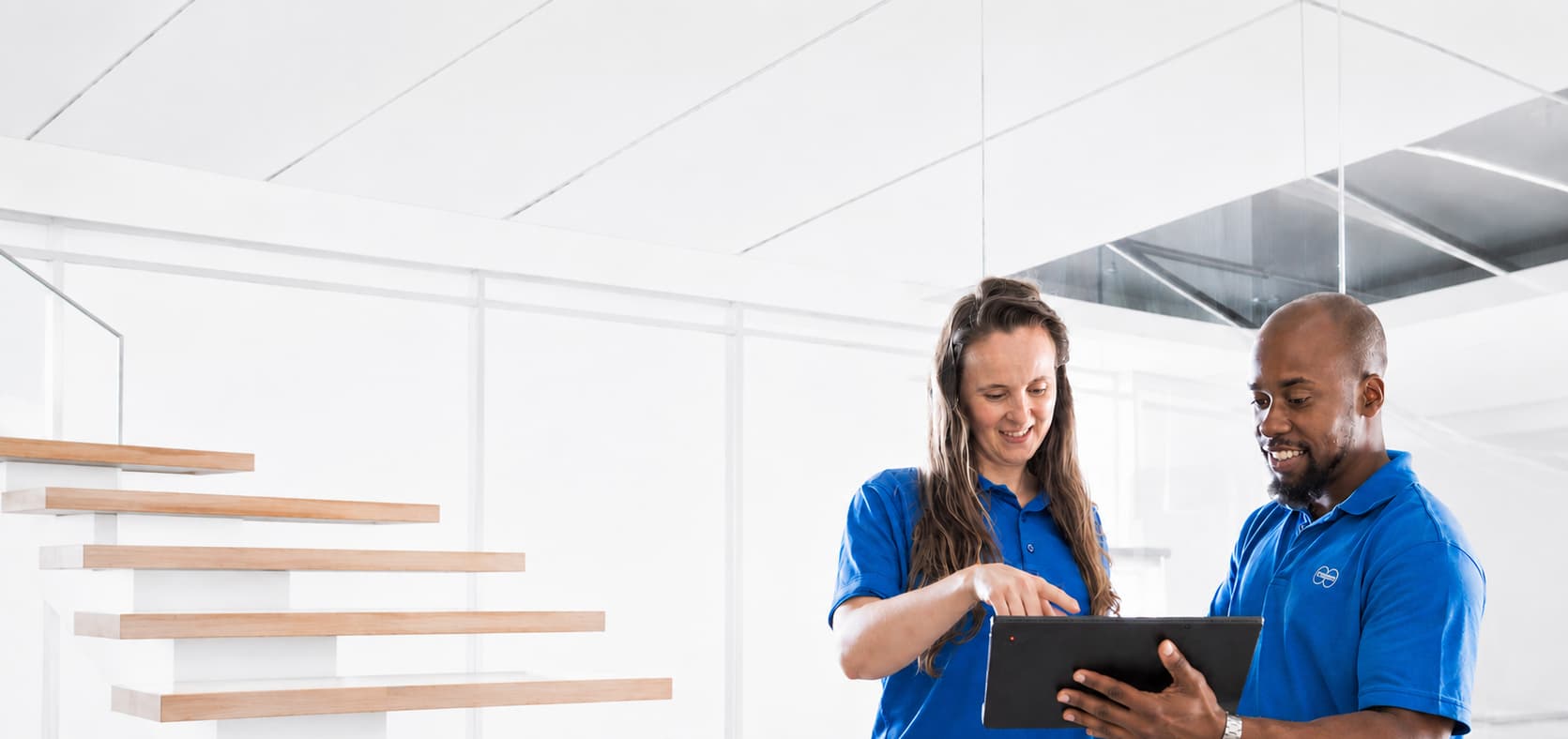 Two Körber employees analysing reading the sustainability report 2025f on a tablet.