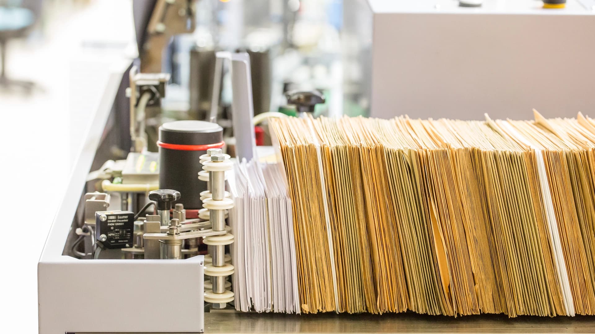 A bunch of mail being handled in a machine.