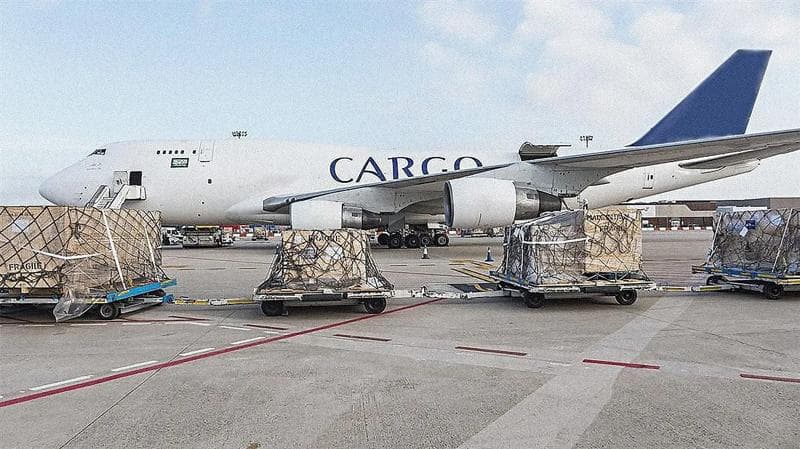 Ein Frachtflugzeug mit großen Paketen davor, die zum Transport bereitstehen.