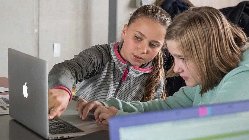 Zwei Mädchen arbeiten auf der Code Week Hamburg an einem Computer.