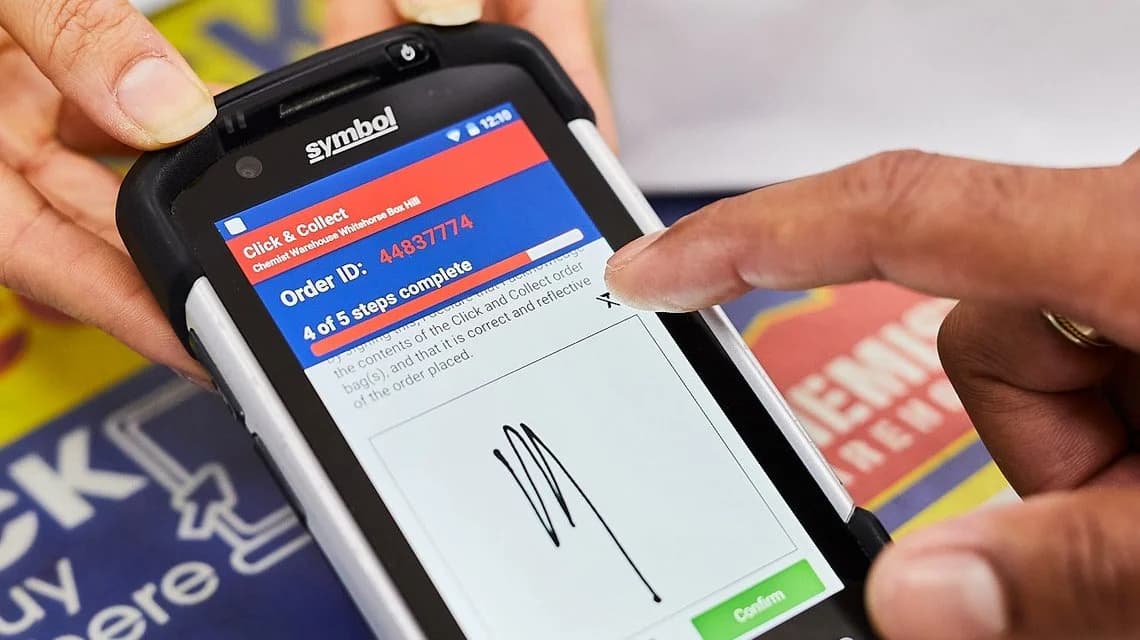 A shopper using a click and collect machine at a store.