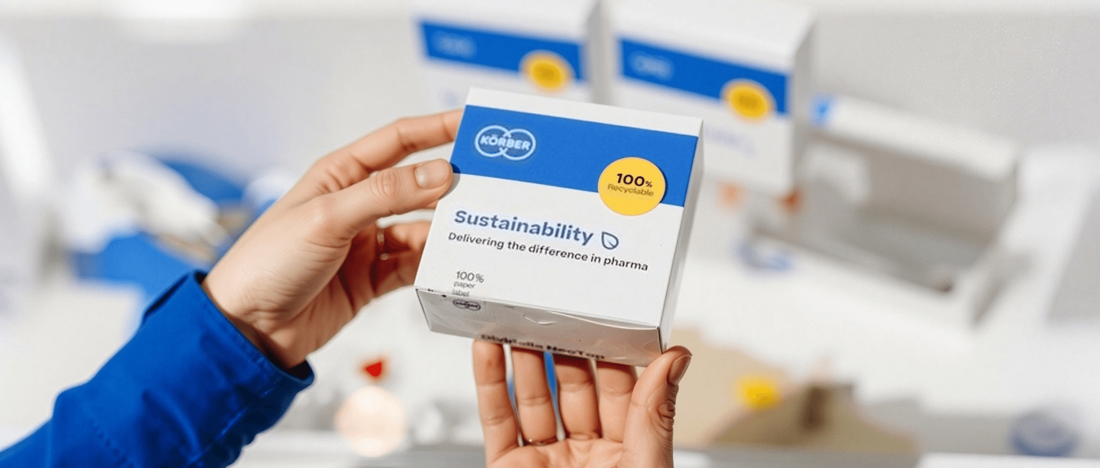 Nahaufnahme von Händen, die eine Körber-Pharmaverpackung halten