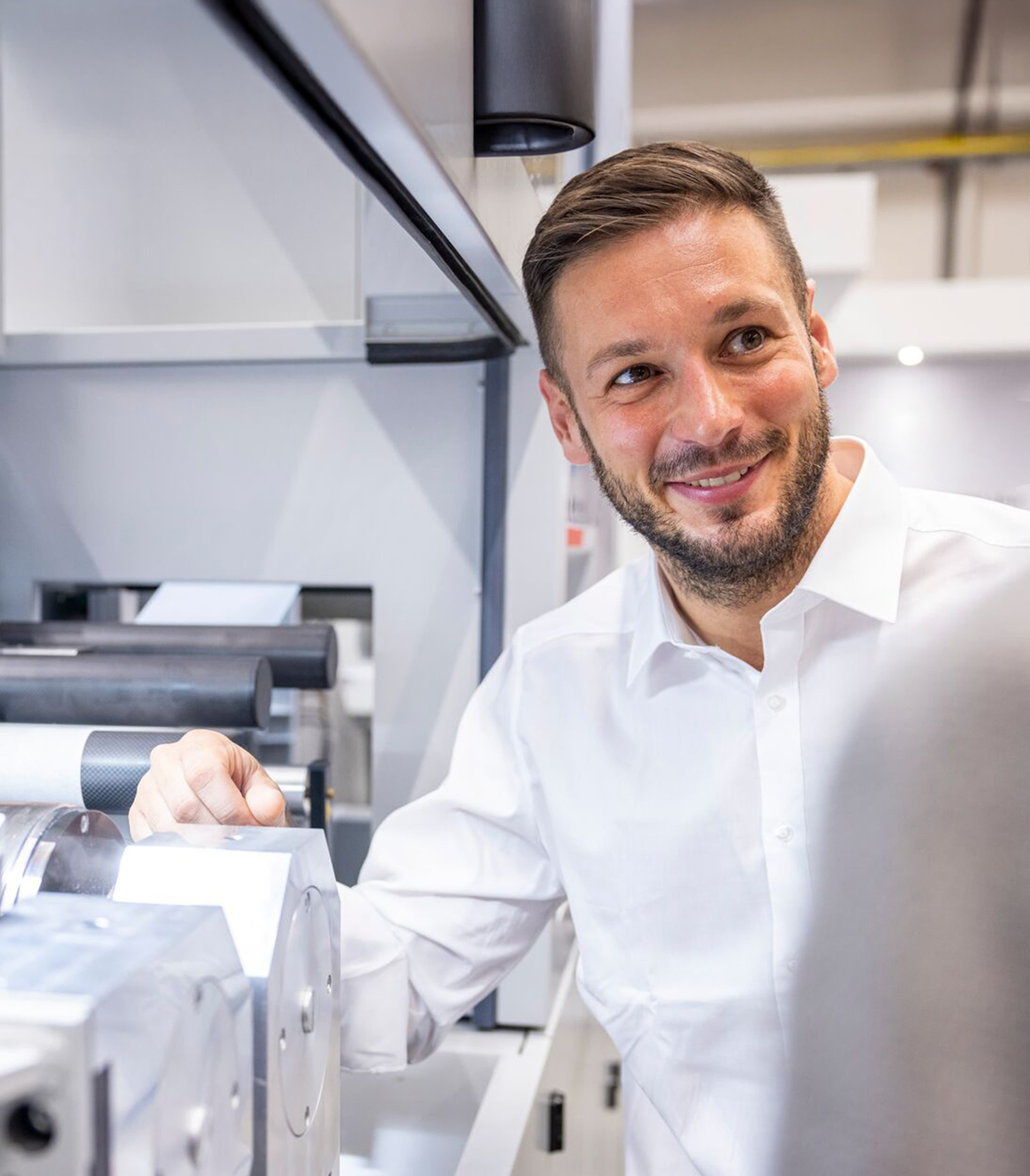 Engineer smiling next to machinery