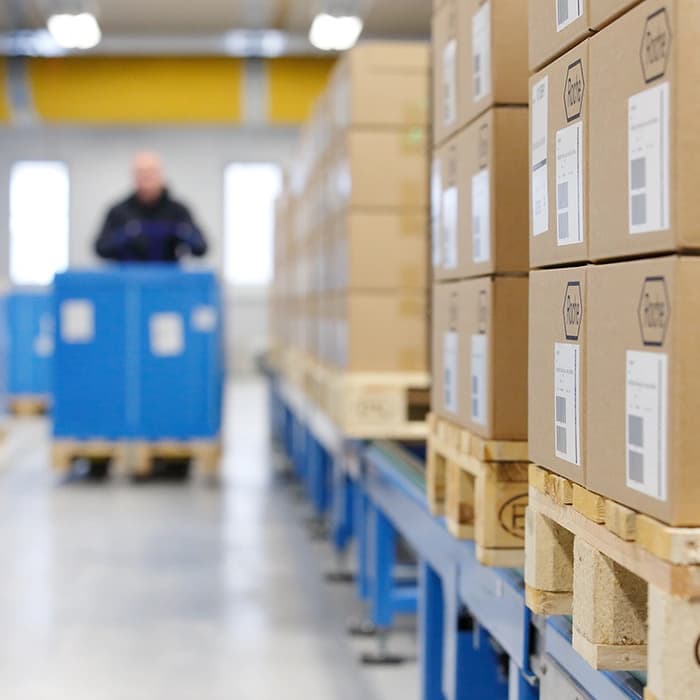 A man is organizing items on shelves in Roche's warehouse