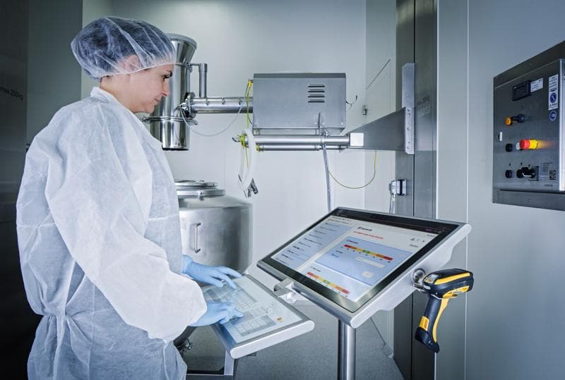 Korber-Ingenieur mit Schutzausrüstung und Blick auf einen Computer