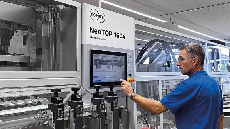 Körber-Mitarbeiter bei der Arbeit an der Dividella NeoTop Verpackungsmaschine.