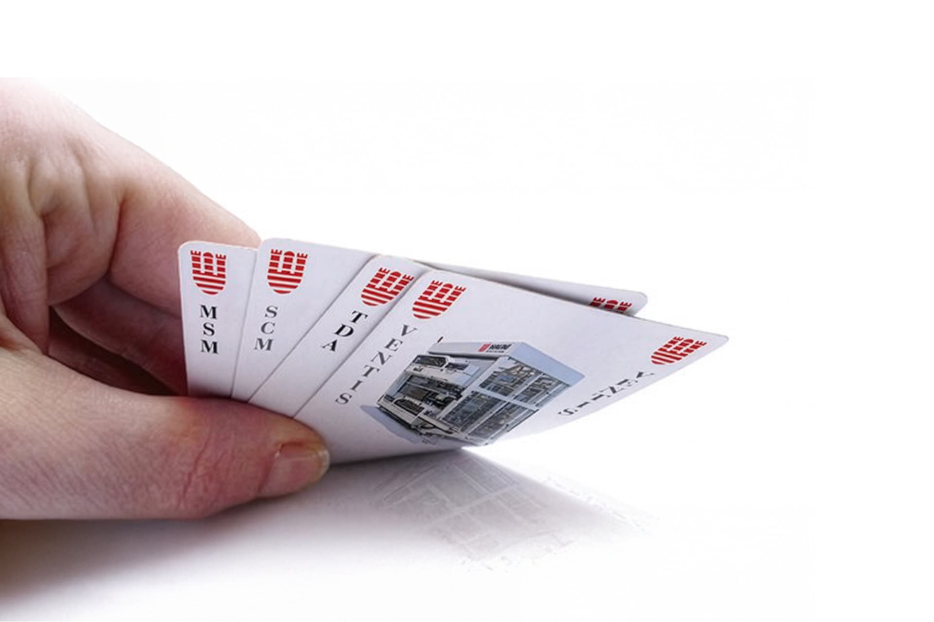 A hand holds four playing cards.