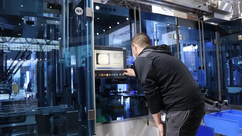 Person experimentiert mit einer Pharmamaschine von Körber.