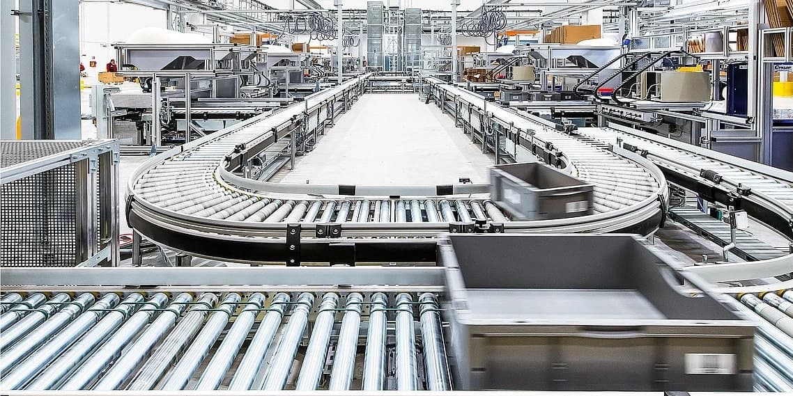 conveyor belt in a factory is in motion, carrying goods for processing.