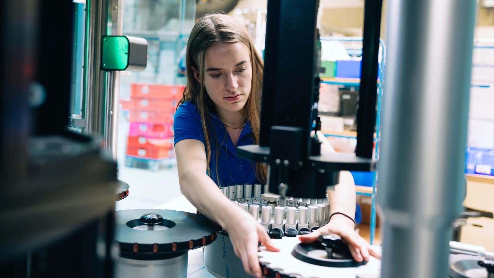 Eine Frau arbeitet an einer Maschine in der Fabrik, umgeben von wichtigen Werkzeugen und Geräten für die Produktion.