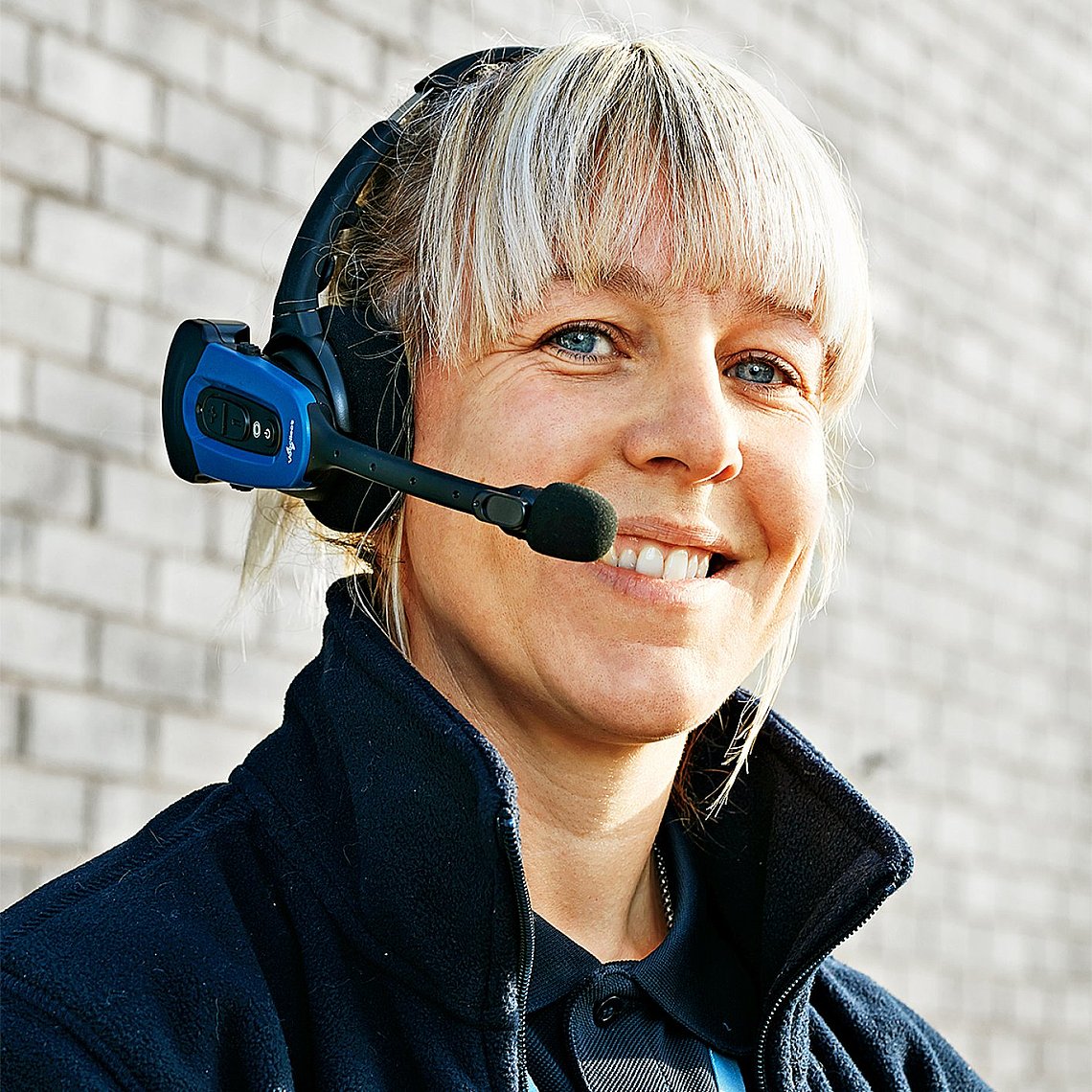 A smiling woman wearing a headset