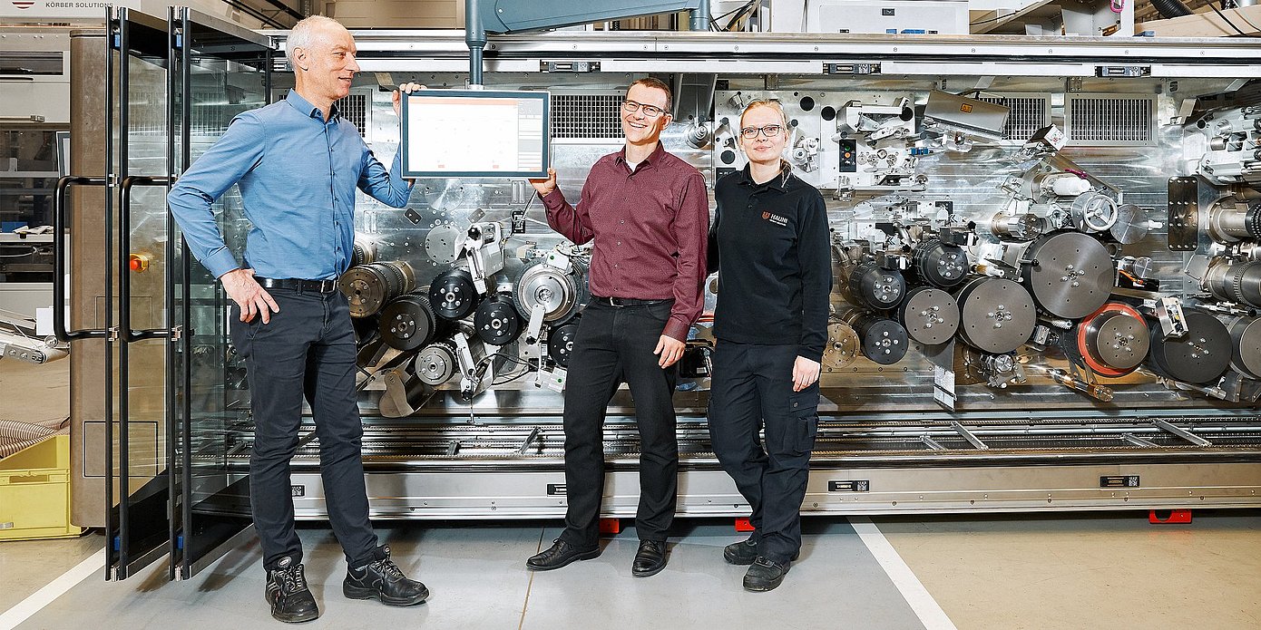 Foto der Hauni-Mitarbeiter Karsten Barsch, Christian Junge und Nina Gröncke vor einer Maschine, dem Multi-Segment-Maker