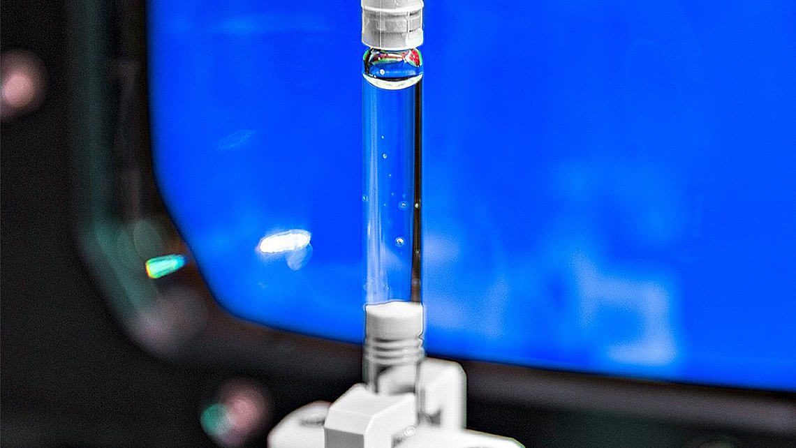 Photo of a filled syringe clamped in a measuring device 