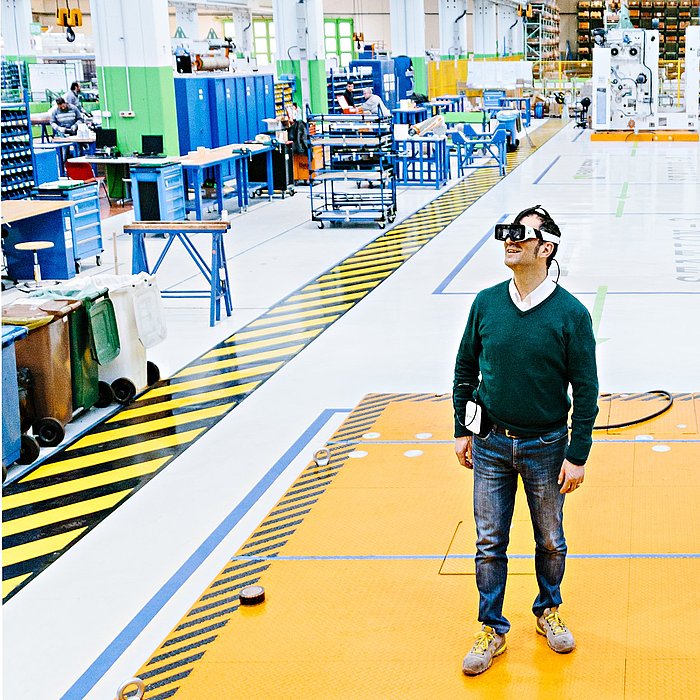 Foto von Giulio Ricci, der mit Weareable Glasses in der Produktionshalle von Fabio Perini in Lucca steht