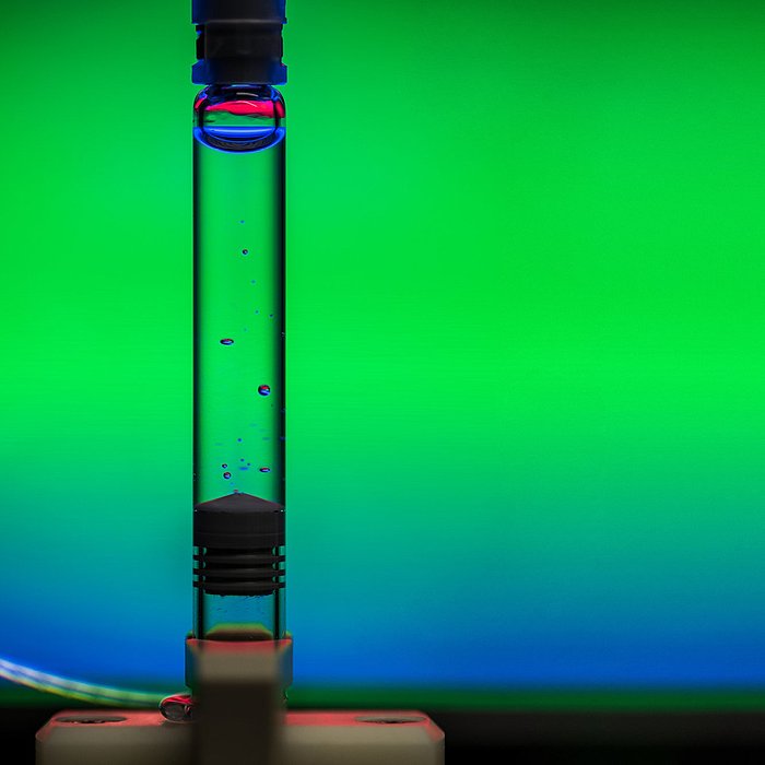 Foto einer gefüllten Spritze, in der klaren Flüssigkeit treiben Luftblasen.