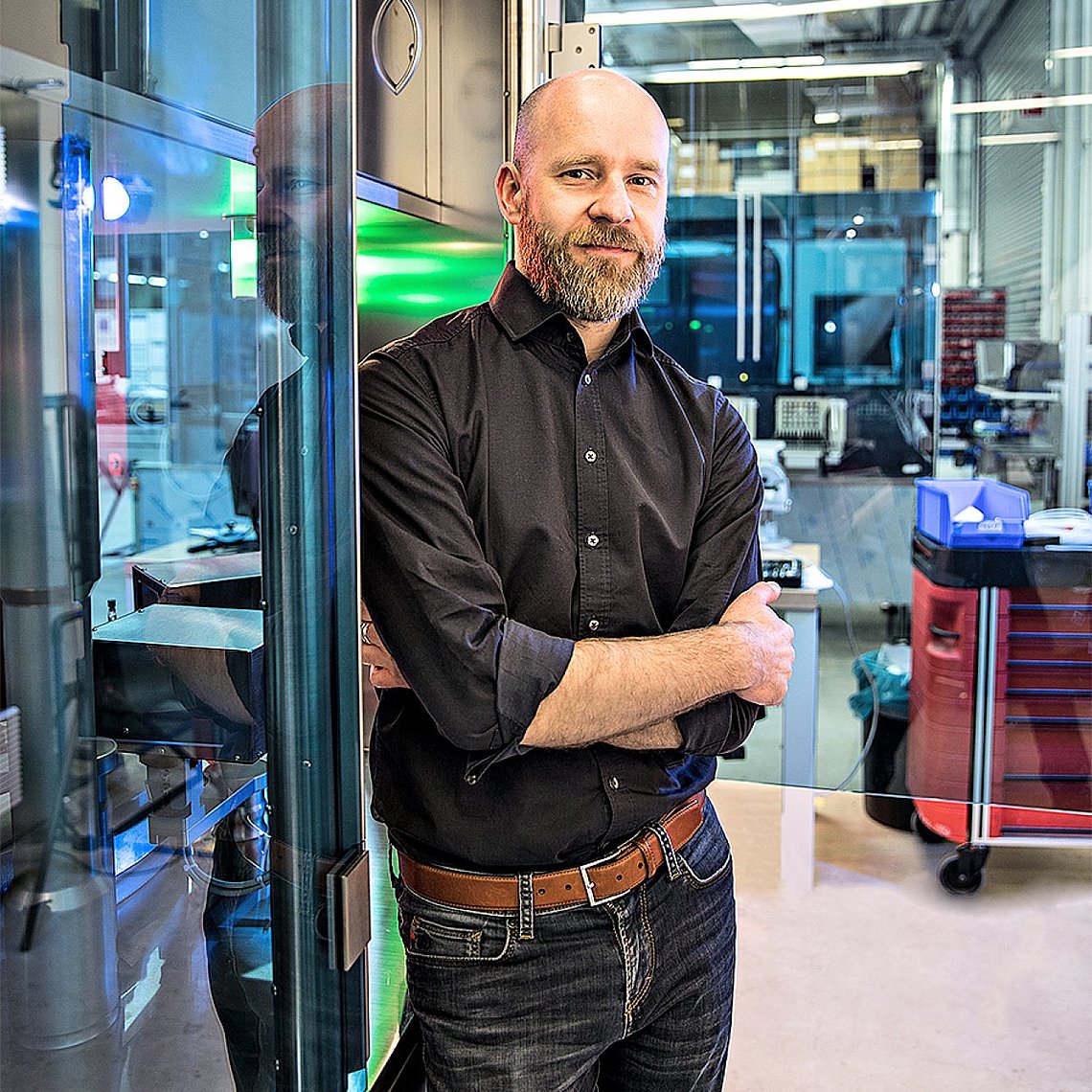 Portrait photo of an engineer standing in front of a machine